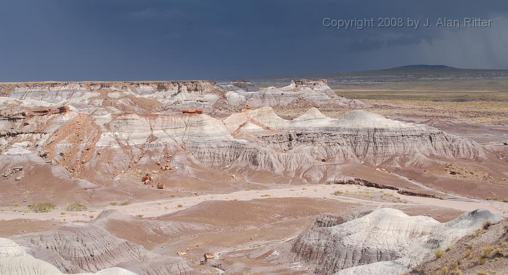 Slide_008.jpg - Some of the "badlands" features in the sunlight with the dark thunderclouds behind.